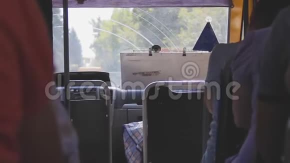 普通公共汽车的内景挡风玻璃后面的景观变化人们坐在乘客座位上通道之间视频的预览图
