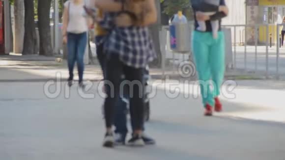 人们在夏天走在街上模糊的焦点一对年轻的情侣抱着女孩去做他们的生意视频的预览图