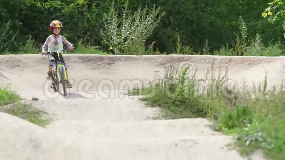 一个戴头盔的男孩骑自行车在山上视频的预览图