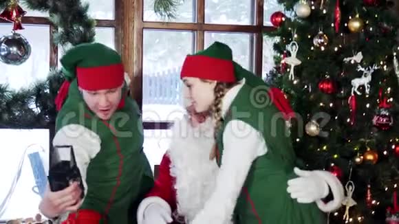 圣诞老人和精灵在圣诞节装饰背景下自拍视频的预览图