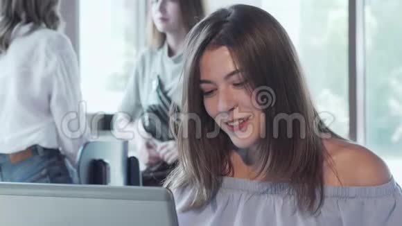 美丽的女人在咖啡店的笔记本电脑上聊天视频的预览图
