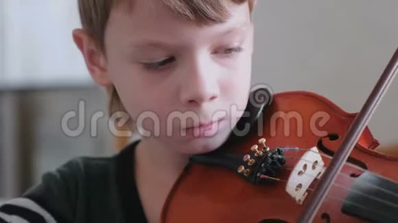 八岁的男孩正在学习拉小提琴视频的预览图