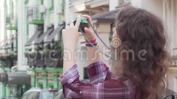 年轻女子在室外拍照时对着镜头微笑视频的预览图