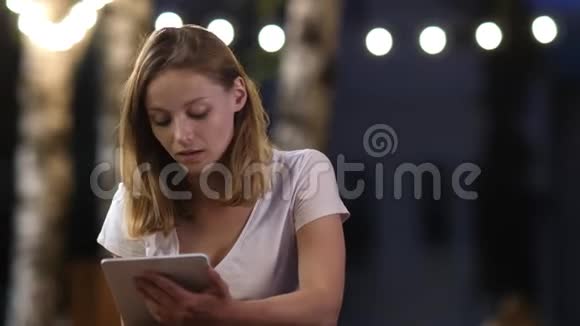 十几岁的女孩坐在户外咖啡馆里用平板电脑视频的预览图