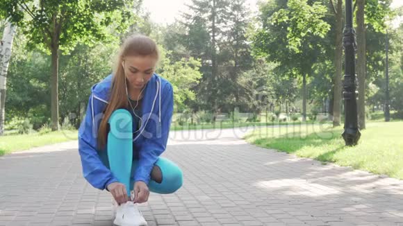 美丽的女运动员在公园跑步前系好鞋带视频的预览图