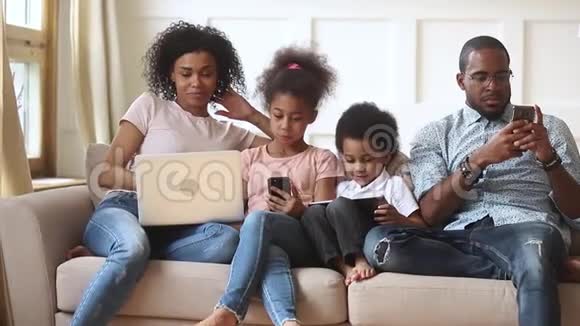 非洲夫妇和小孩沉迷于现代小玩意视频的预览图