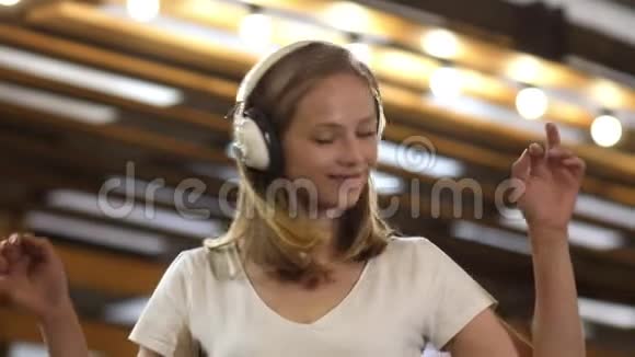 金发美女带着耳机听音乐跳舞视频的预览图