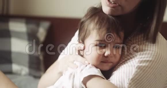 年轻的母亲安慰她心烦意乱的婴儿女儿视频的预览图