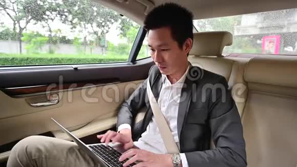 4年轻商人在汽车后座使用笔记本电脑视频的预览图