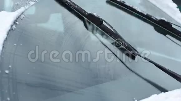 冬天汽车刮水器将挡风玻璃从积雪中清除干净视频的预览图