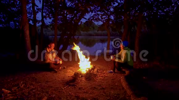 一男一女靠近夜林的火堆视频的预览图