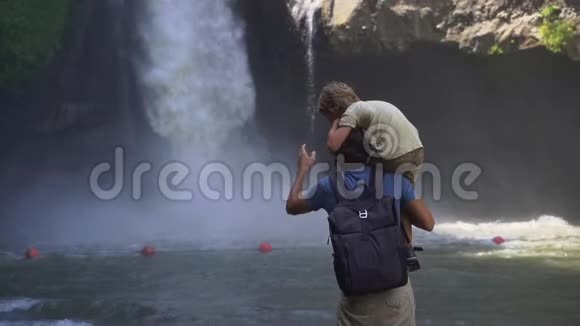 在巴厘岛乌布达岛上参观特根甘瀑布的父子慢镜头视频的预览图