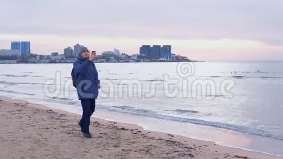 冬季在沿海城市海上行走的男子旅行者在电话中聊天视频视频的预览图