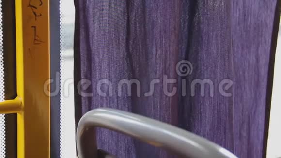 紫丁香的窗帘在公共汽车的玻璃附近晃动夏天一条紫色的窗帘在选秀中飘扬普通公共汽车的内景视频的预览图