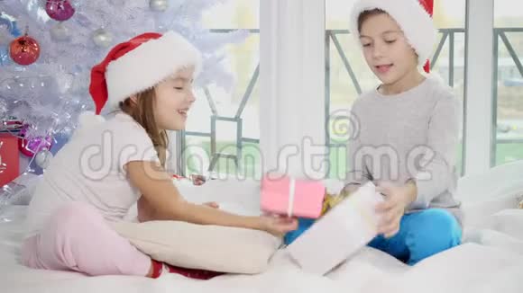 小兄弟比较他们的礼物这个男孩很高兴有一个大礼盒而他妹妹有一个小礼盒视频的预览图