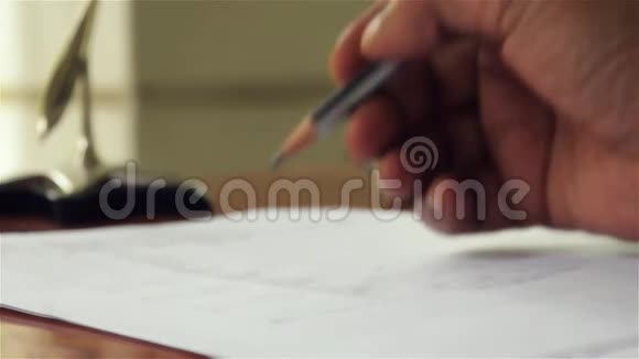 人的特写他的手在桌上用钢笔写一张纸文件做财务报告的商人贷款视频的预览图