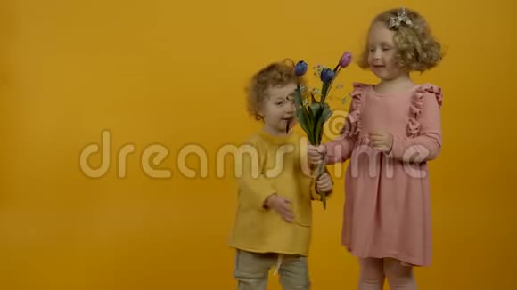 可爱的卷发孩子微笑着拥抱妹妹视频的预览图