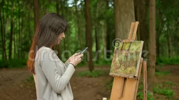 这位女艺术家在她的智能手机上完成了她的绘画和聊天工作视频的预览图