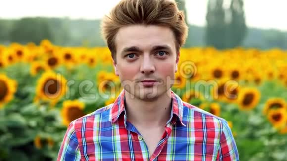 酷又时尚的年轻男性农民戴上太阳镜在向日葵的背景上视频的预览图