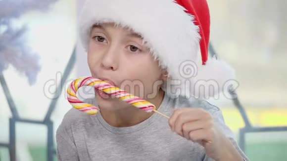 漂亮的小男孩正在品尝一种糖果在圣诞节的早晨看起来很好奇视频的预览图