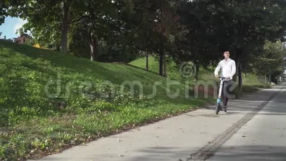 青年休闲商务学生骑电动滑板车在人行道上视频的预览图