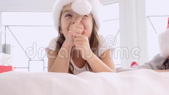 小公主的可爱维多躺在床上把软球推到圣诞老人的帽子上微笑着视频的预览图