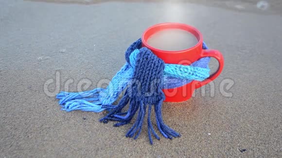 带咖啡和蒸汽的红色杯子和蓝色针织围巾支架视频的预览图