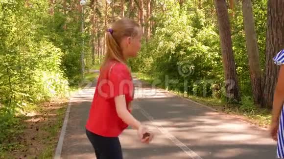 十几岁的女孩扔冷杉锥一起在自然公园玩游戏视频的预览图