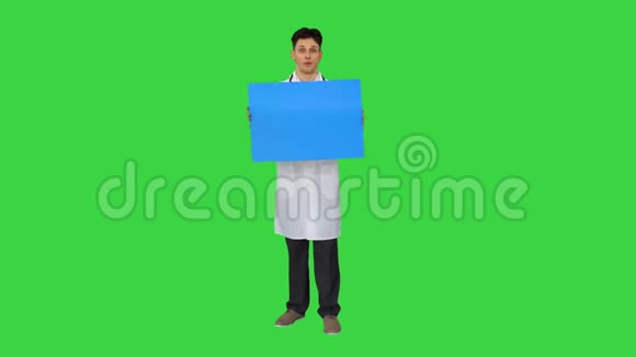 快乐微笑的男医生展示空白的招牌并在绿色屏幕上跳舞Chroma键视频的预览图