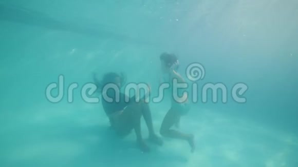 妈妈和女儿一起在游泳池里水下潜水视频的预览图