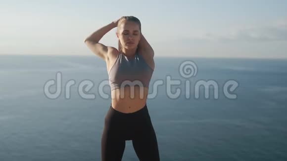 女人早上做运动和伸展运动背景是大海动作缓慢视频的预览图