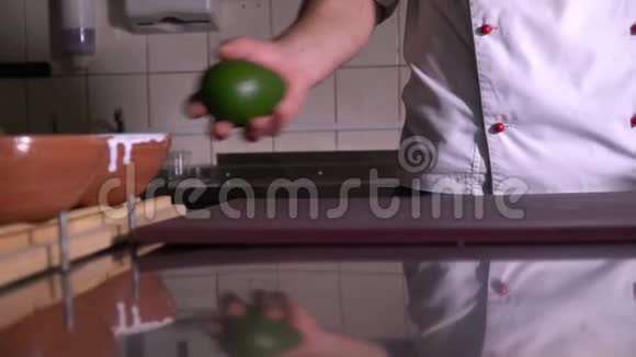 餐厅的厨房厨师正在切菜板上滚动鳄梨视频的预览图