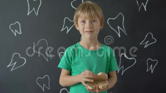 小男孩给他的牛奶牙齿展示了一个木箱儿童换牙的概念视频的预览图