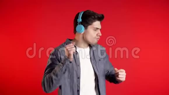 带着耳机的帅哥在红色背景下跳舞派对音乐生活方式收音机和迪斯科的概念视频的预览图