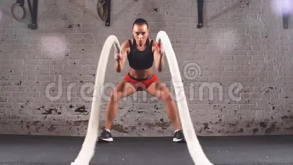 运动女性在交叉健身运动中积极参加带战斗绳索的健身运动视频的预览图