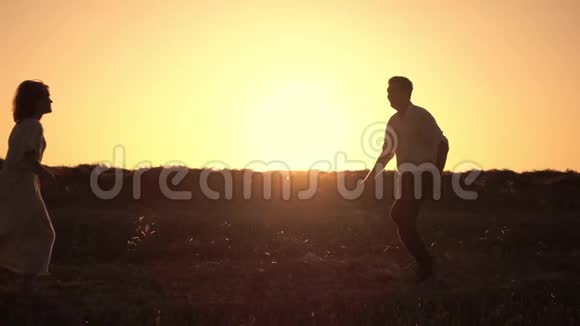 浪漫的情侣在夕阳的背景下旋转拥抱视频的预览图