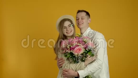 快乐的一对带着鲜花微笑拥抱的情侣视频的预览图