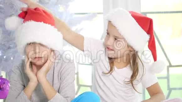 小妹妹逗着她恼羞成怒的弟弟拉着他的圣诞帽从一边蹦到另一边微笑着但是视频的预览图