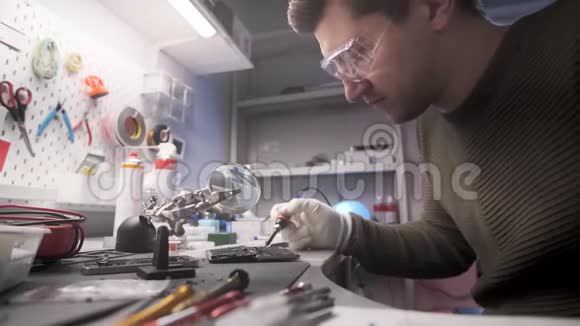 电子修理工在智能手机板上进行焊接工作视频的预览图