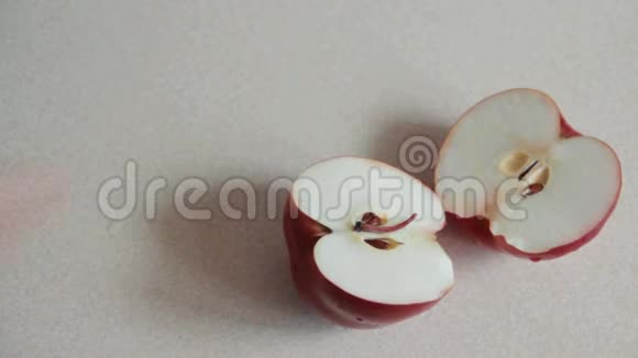 雄手分开把红苹果切成两部分放在桌子上雄手捧一个有水滴的红苹果素食者准备水果视频的预览图