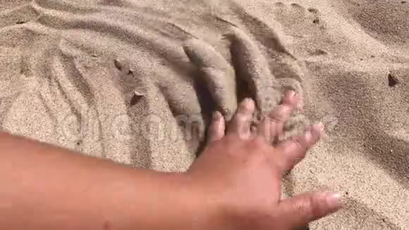 人的手把沙子从他的手指里撒出来视频的预览图