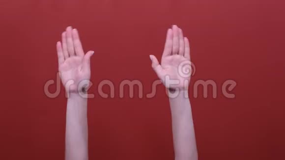 女人的手在舞池里挥舞着手在舞池里的红色背景下随着音乐的节奏拍打着她的手指视频的预览图