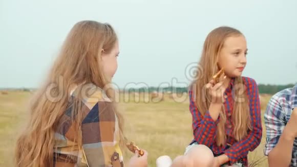 可爱的男孩和女孩一起在野外吃披萨视频的预览图