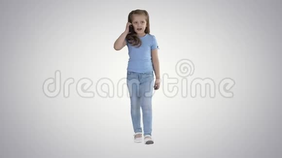 小可爱的女孩在梯度背景下散步时打电话视频的预览图