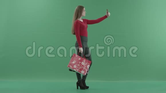 穿着休闲服的漂亮女人拿着购物袋在手机上自拍她站在右边视频的预览图