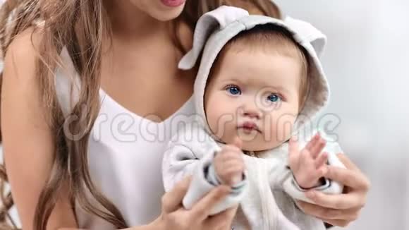 聚焦可爱宝宝穿着白色衣服拍手看镜头特写的画像视频的预览图