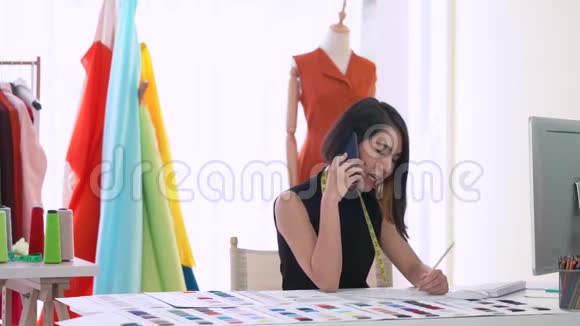亚洲小企业主在办公室工作时打电话服装商店和时装设计师视频的预览图