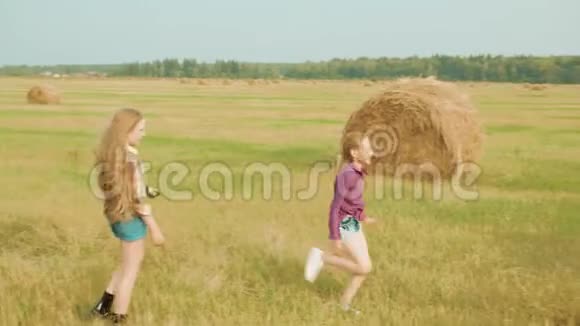 少女奔跑攀登干草堆稻草卷收获时间视频的预览图