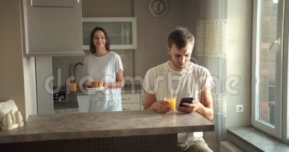 夫妇早餐吃果汁和牛角面包视频的预览图