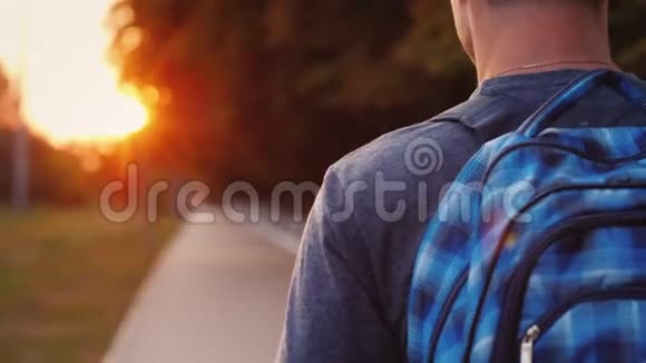 一个带着背包的青少年正沿着上学的路走着只有他的肩膀和背包的一部分是可见的视频的预览图